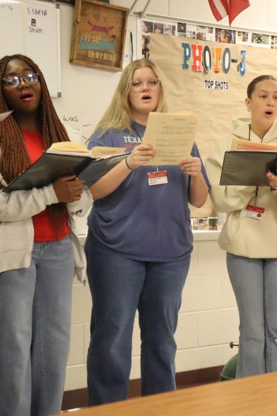 Three choir students sing carols